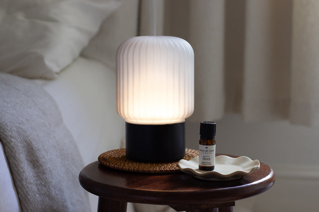 Atmo aroma diffuser on a bedside table with sleep essential oil blend