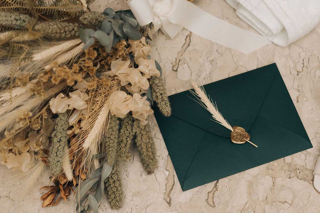 Dried floral bouquet with green envelope and gold seal