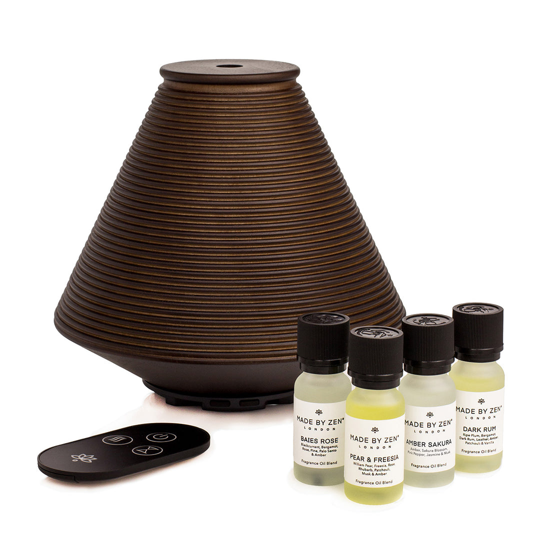 Wooden aroma diffuser with  intricate groove design, offers a variety of mist settings. Supplied with remote control and four fragrance oils